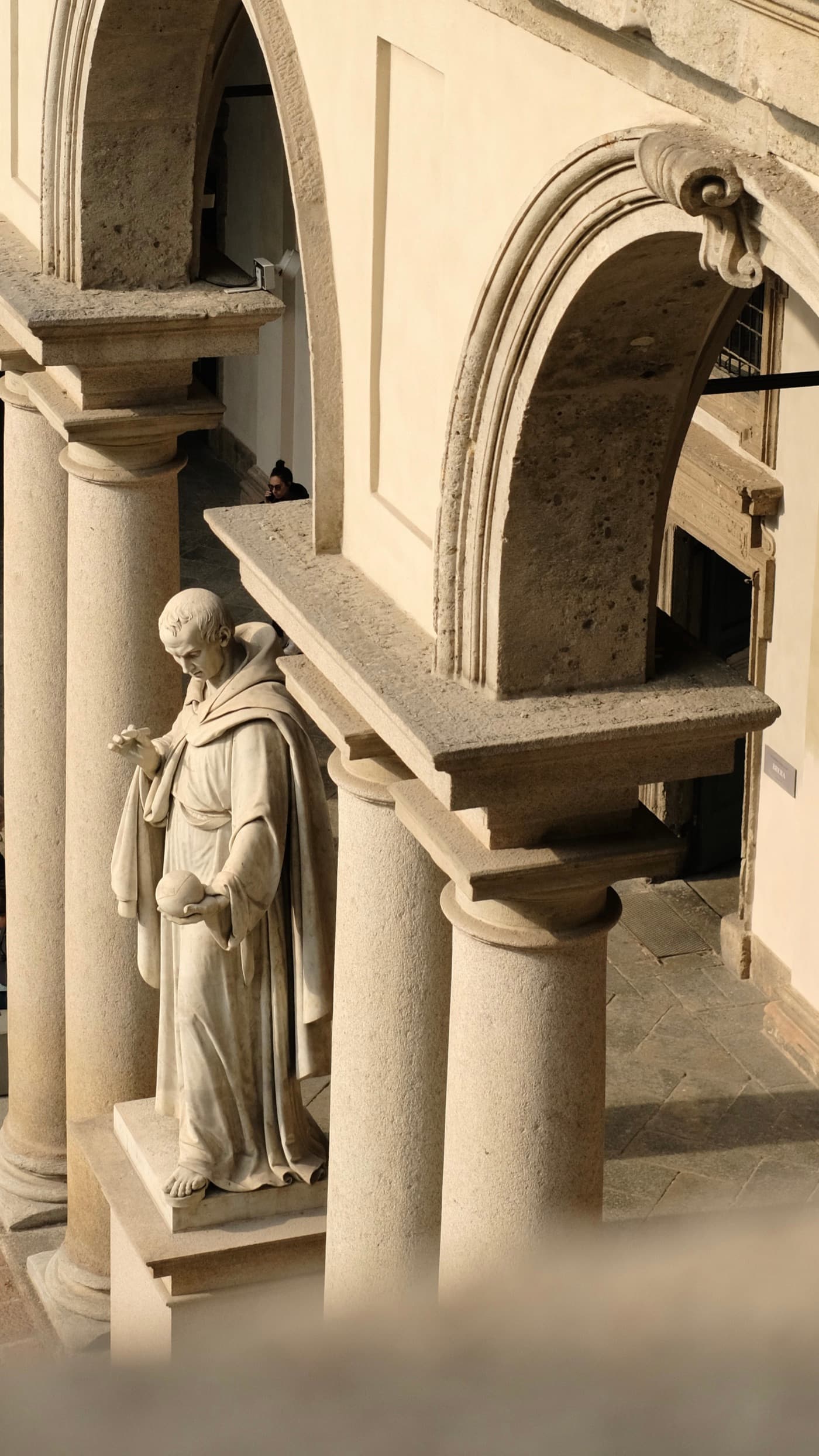 A statue and architectural details inside the Brera Academy arcade