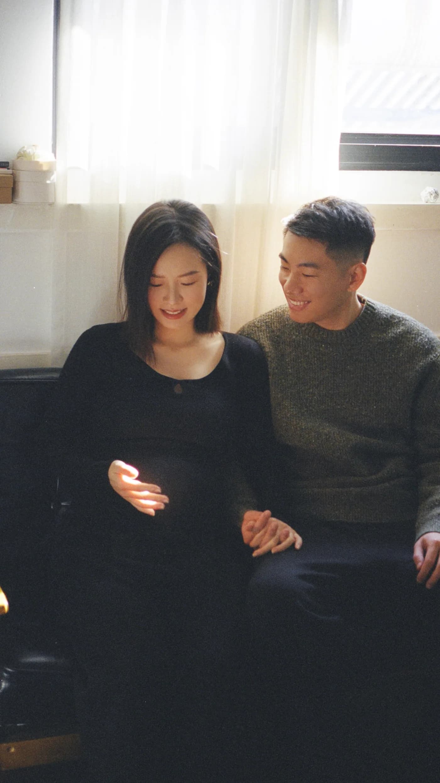 Wentian and her partner sitting by a window during pregnancy