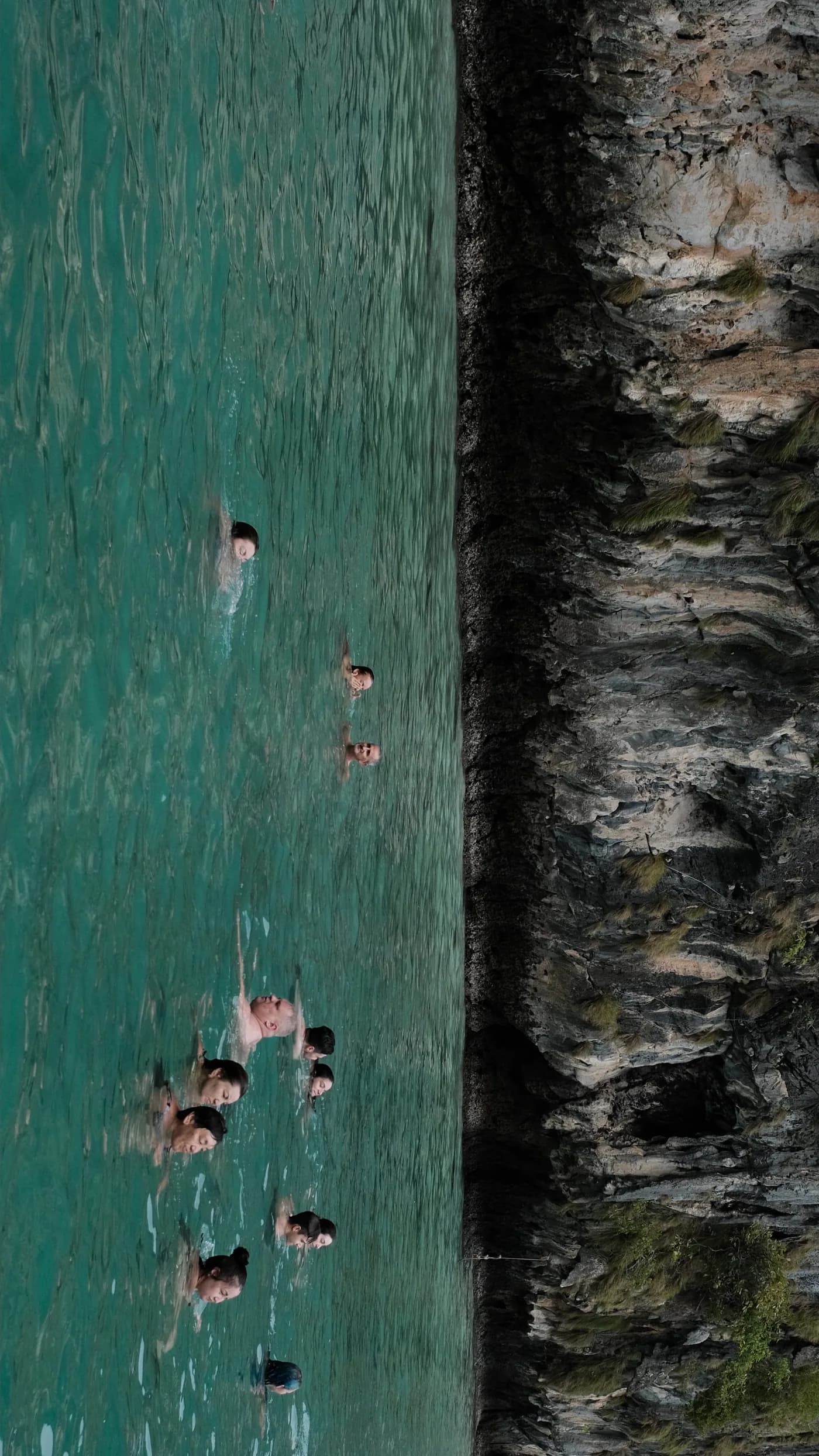 Swimmers seen from above in turquoise water