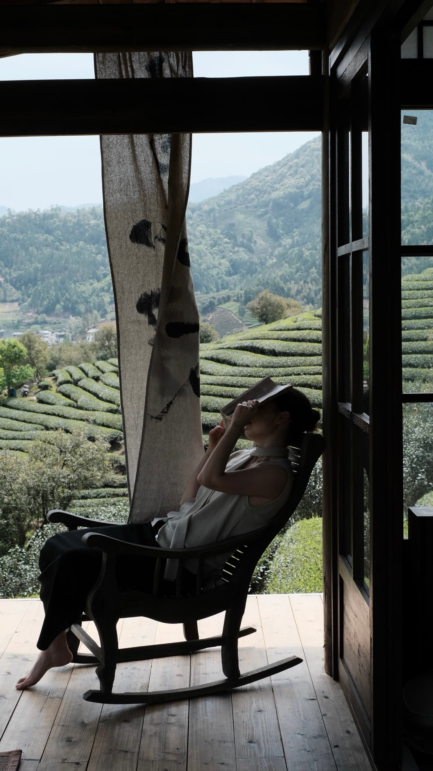 Wentian sitting in a rocking chair overlooking Wuyishan tea fields